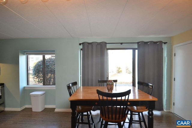 dining space featuring dark wood-style flooring, plenty of natural light, and baseboards