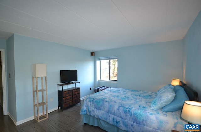 bedroom with dark wood-style flooring and baseboards