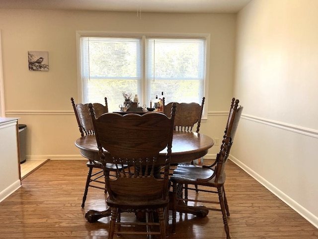 dining space with wood finished floors and baseboards