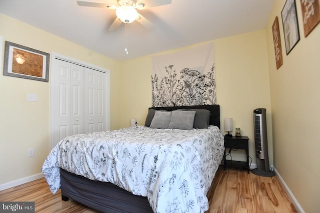 bedroom featuring wood-type flooring, ceiling fan, and a closet