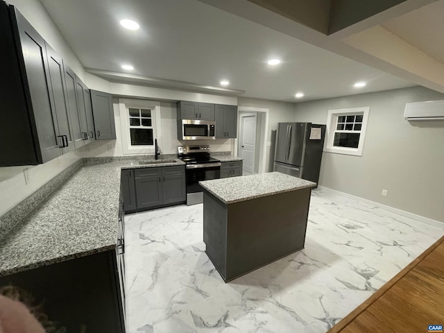 kitchen featuring a kitchen island, appliances with stainless steel finishes, marble finish floor, a sink, and recessed lighting