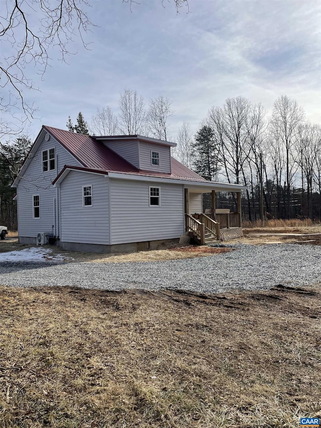 view of side of property with a porch and metal roof