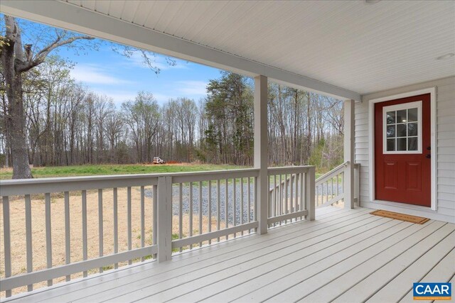 view of front of property with gravel driveway, metal roof, and a porch