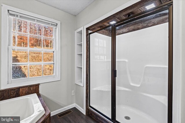 full bath with a healthy amount of sunlight, visible vents, a garden tub, and baseboards