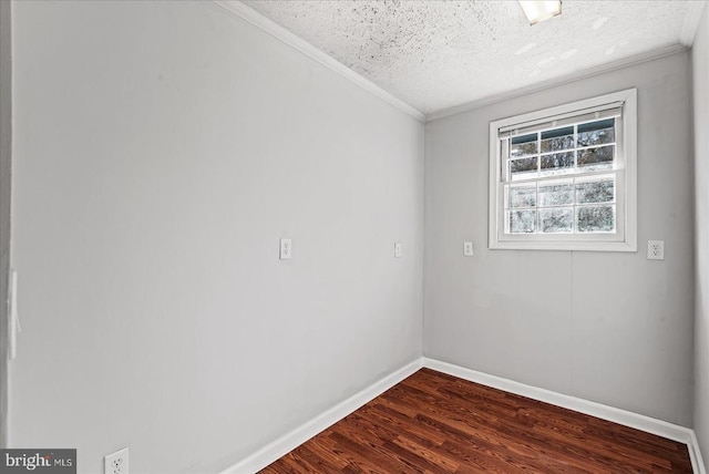 empty room featuring ornamental molding, dark wood-style flooring, a textured ceiling, and baseboards