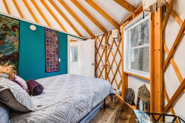 bedroom with lofted ceiling with beams and wood-type flooring