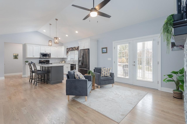 living room featuring ceiling fan, baseboards, vaulted ceiling, french doors, and light wood finished floors