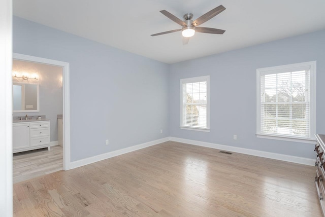 unfurnished bedroom featuring light wood-style floors, baseboards, multiple windows, and visible vents