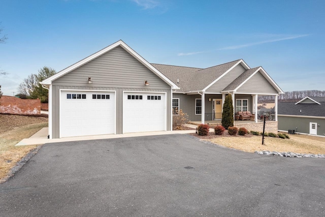 view of front of home with covered porch, aphalt driveway, and a garage