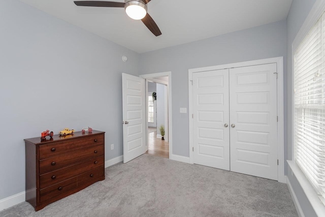 carpeted bedroom featuring ceiling fan, baseboards, and a closet