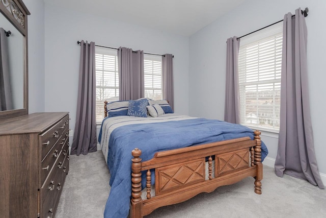 bedroom with baseboards and light colored carpet