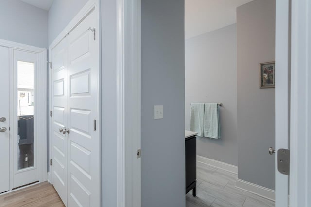 interior space with vanity, baseboards, and wood finished floors