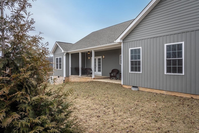 rear view of property with roof with shingles, a patio, a lawn, and french doors