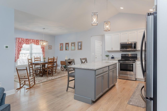 kitchen with light wood-style flooring, gray cabinetry, appliances with stainless steel finishes, white cabinets, and a kitchen island