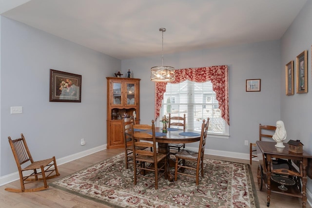 dining room featuring light wood finished floors and baseboards