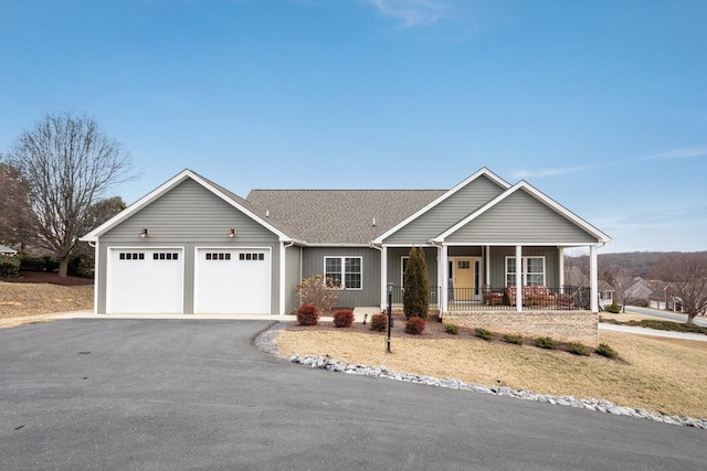 ranch-style house with a garage, aphalt driveway, roof with shingles, covered porch, and board and batten siding