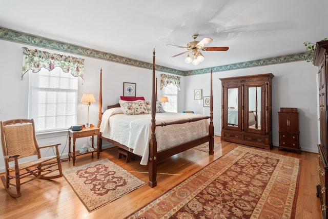 bedroom with hardwood / wood-style flooring, a ceiling fan, and baseboards