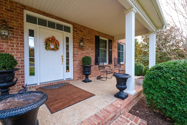 property entrance featuring brick siding and covered porch