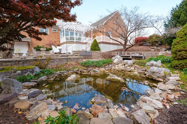 view of yard with a small pond and a pergola