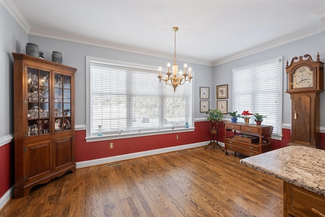 dining area with visible vents, crown molding, baseboards, a chandelier, and wood finished floors