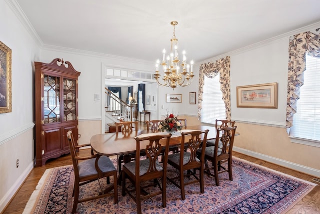 dining space with a chandelier, ornamental molding, stairs, and wood finished floors