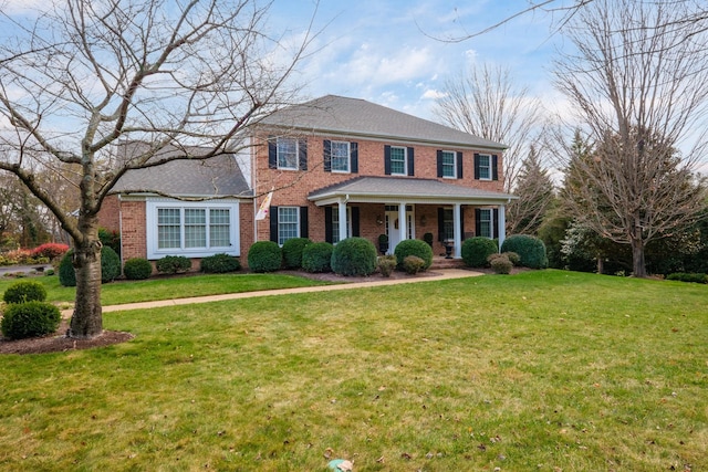 view of front of house featuring a front yard, a porch, and brick siding