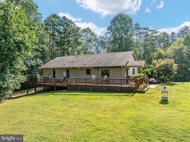 back of property with an outdoor fire pit, a deck, and a lawn