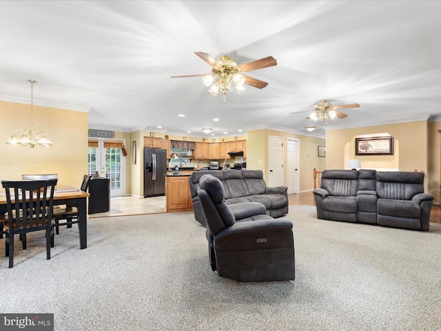 living room featuring ceiling fan with notable chandelier, ornamental molding, and light colored carpet