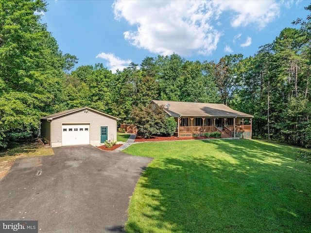 single story home with an outbuilding, a garage, a front lawn, and covered porch