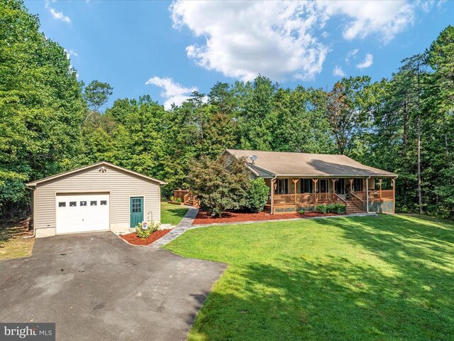 ranch-style home featuring a porch, a garage, an outdoor structure, and a front lawn