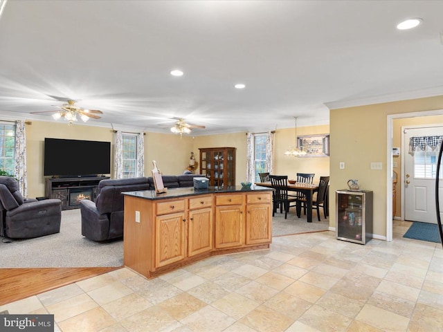 kitchen featuring wine cooler, ceiling fan, ornamental molding, and a center island