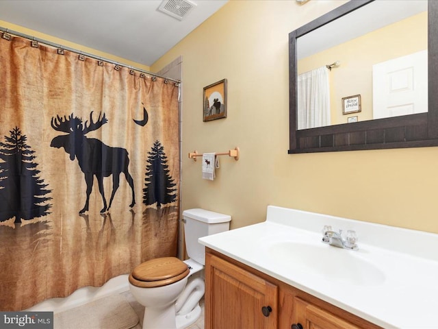 bathroom with walk in shower, vanity, and toilet