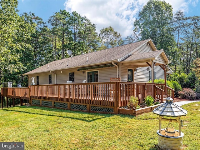 rear view of property with a wooden deck and a yard