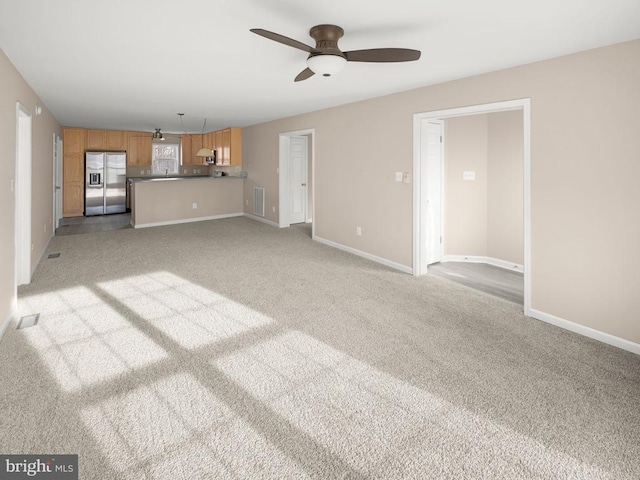 unfurnished living room with light carpet, baseboards, and visible vents