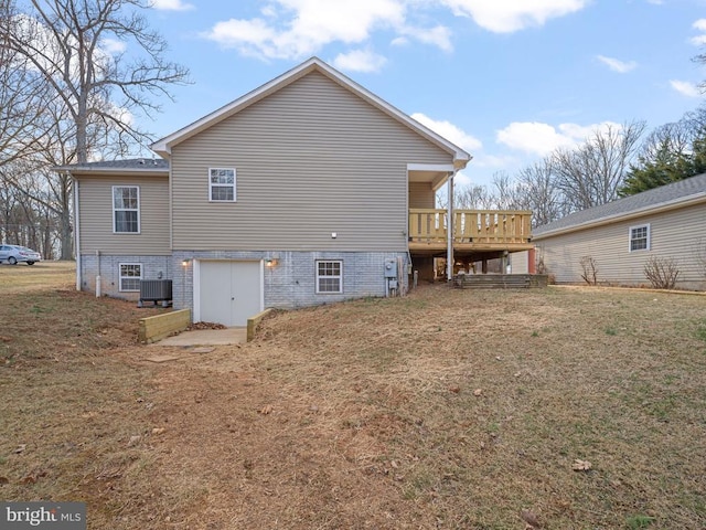 back of house featuring central air condition unit, a deck, and a yard