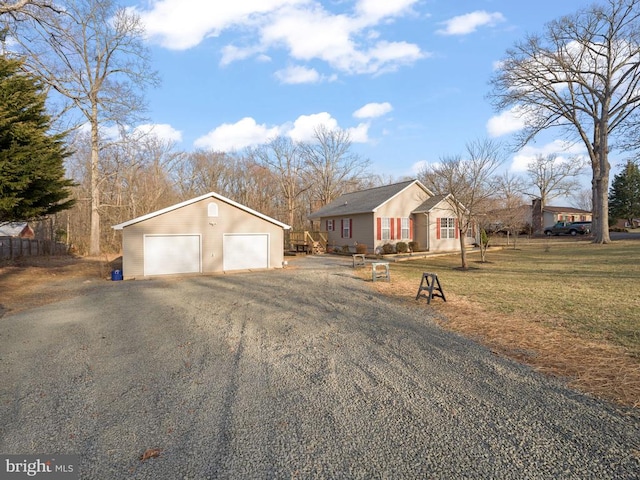 view of front of home featuring a garage, a front yard, and an outdoor structure