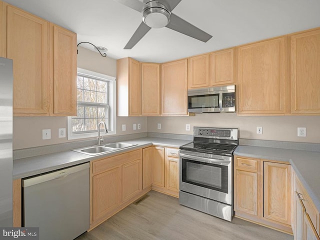 kitchen with light brown cabinets, light wood-style flooring, a sink, visible vents, and appliances with stainless steel finishes