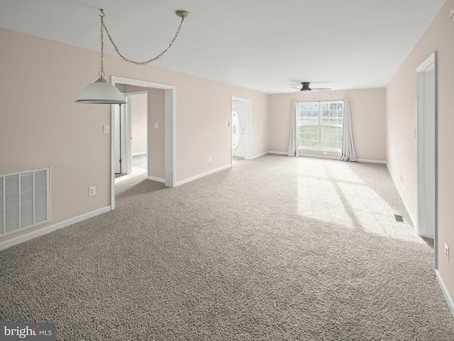 empty room with a ceiling fan, baseboards, visible vents, and carpet flooring