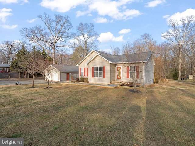 ranch-style home featuring an outbuilding, a front lawn, and a garage