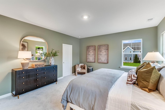 carpeted bedroom featuring baseboards, multiple windows, and visible vents
