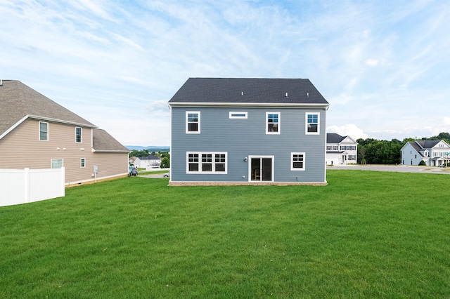 back of house featuring a yard and fence