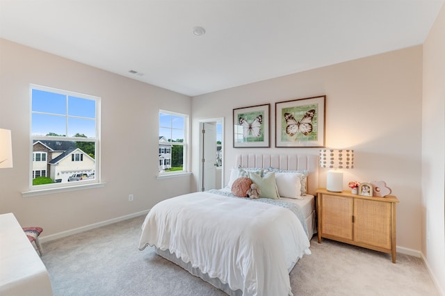 bedroom with baseboards, light colored carpet, and visible vents