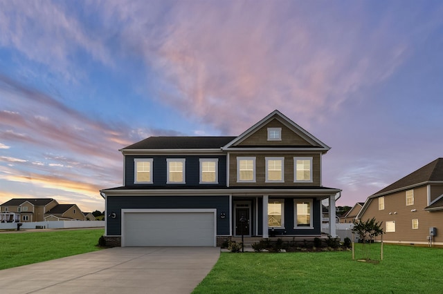 craftsman-style house featuring a porch, an attached garage, a lawn, and concrete driveway