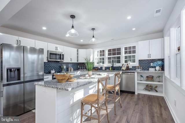 kitchen with visible vents, decorative backsplash, appliances with stainless steel finishes, white cabinetry, and open shelves