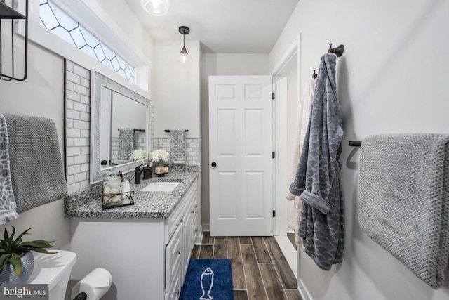 bathroom featuring tasteful backsplash, wood finish floors, and vanity