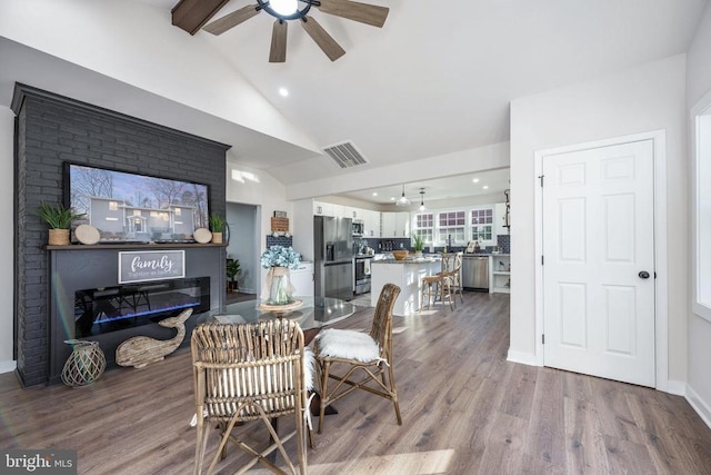 living room with lofted ceiling, dark wood-style floors, visible vents, and baseboards