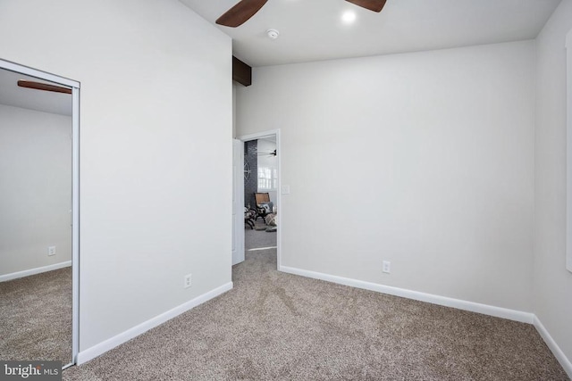 unfurnished bedroom featuring carpet, vaulted ceiling, and baseboards