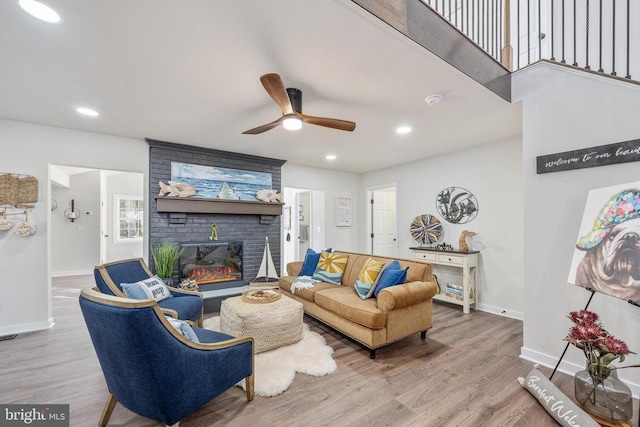 living area featuring recessed lighting, a fireplace, baseboards, and wood finished floors