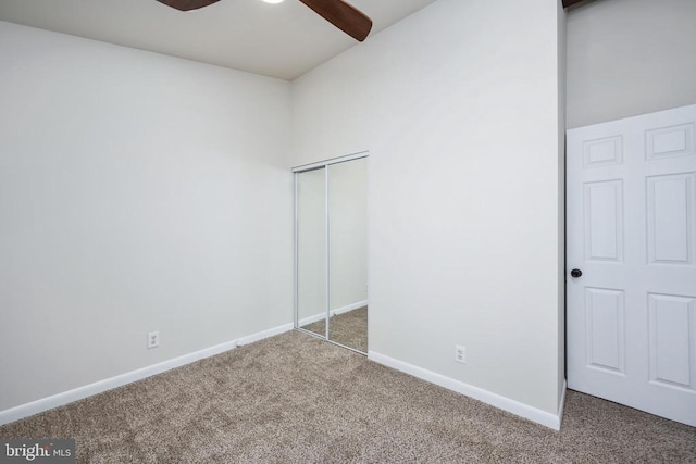 unfurnished bedroom featuring a ceiling fan, carpet, baseboards, and a closet