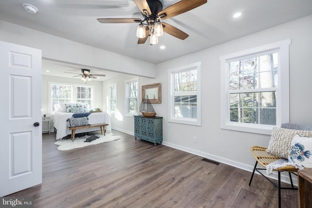 bedroom with multiple windows, dark wood-style flooring, visible vents, and baseboards